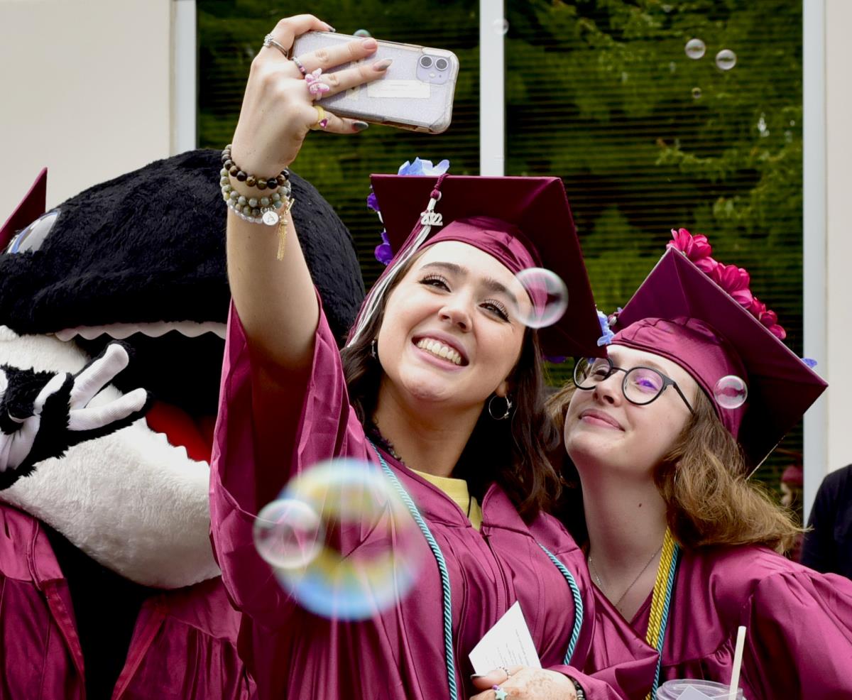 An image of two graduates taking a selfie together