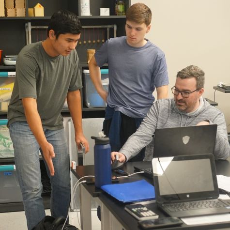 Three Engineering in Context students discuss an assignment in the engineering lab