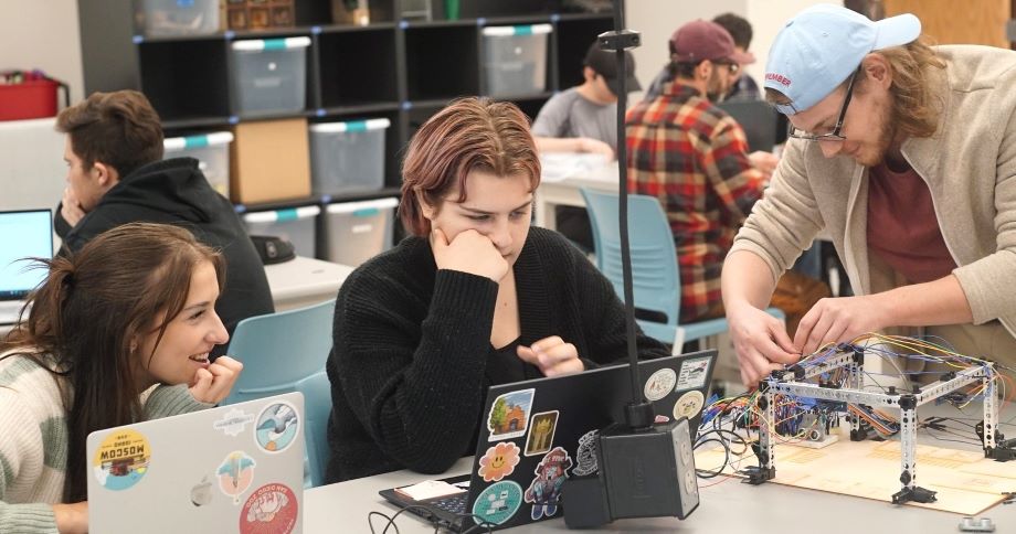 A team of students works on an ENGR 151 assignment
