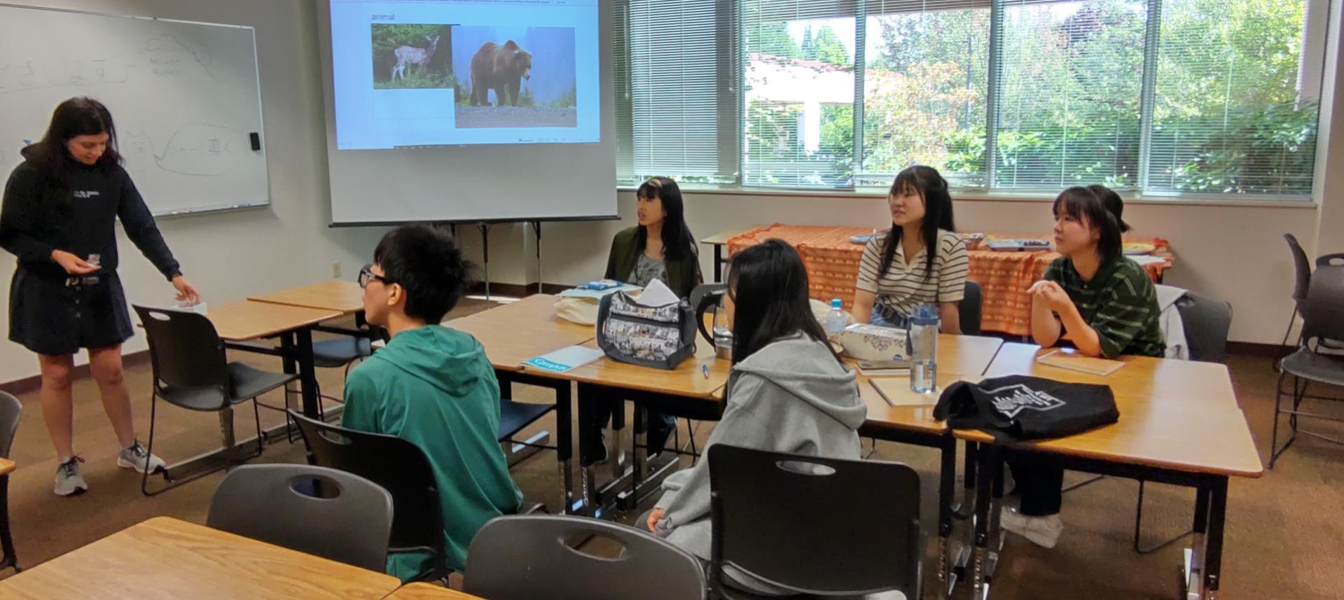 Gabriela Llanos sitting with International Students in a classroom